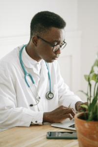 a doctor typing on his laptop