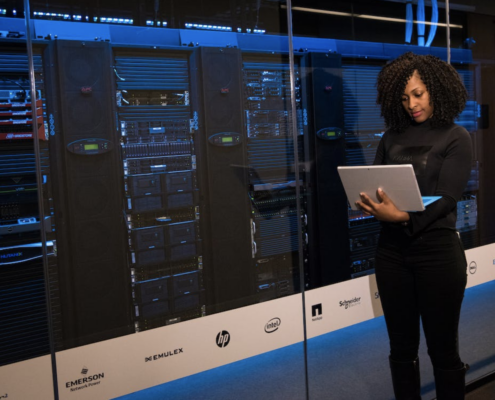 A person using a laptop next to a cloud server